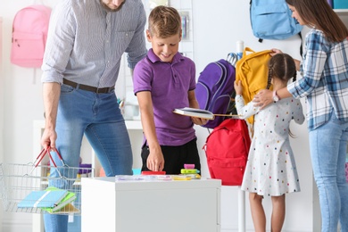 Photo of Children with parents choosing school stationery in store