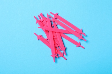 Photo of Pink silicone shoelaces on light blue background, flat lay
