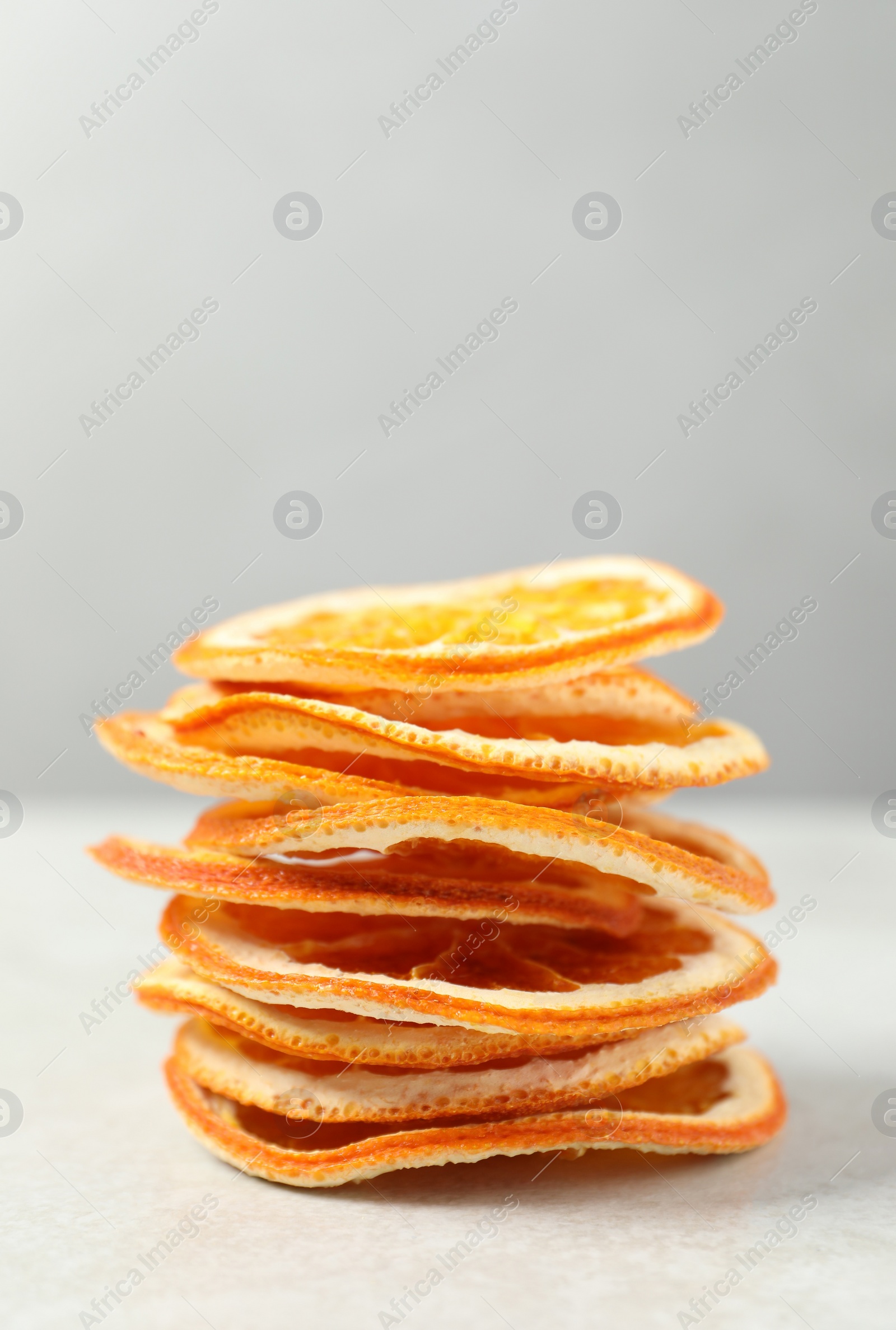 Photo of Stacked dry orange slices on white table, space for text