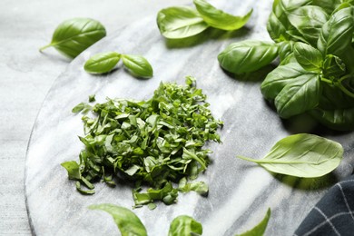 Photo of Fresh green basil on light grey table, closeup