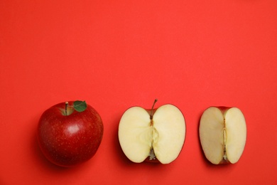 Photo of Flat lay composition with ripe juicy apples on red background, space for text