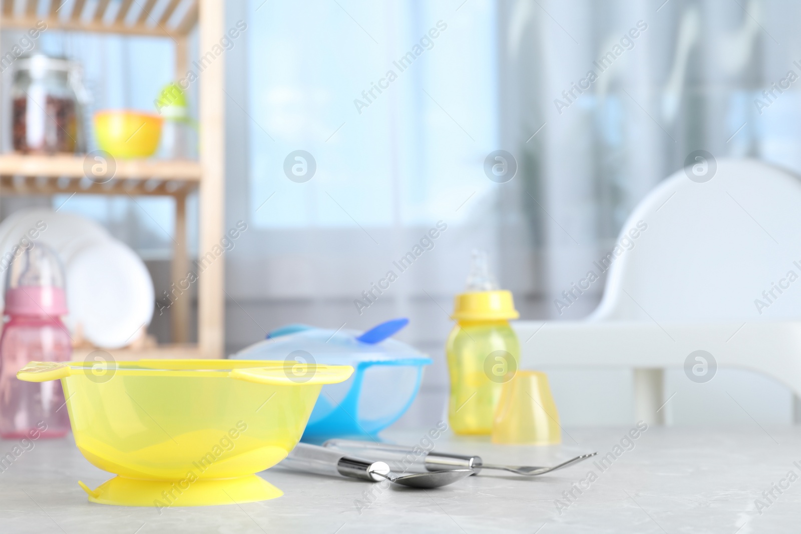 Photo of Bright child's dishware on grey table indoors. Space for text