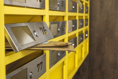Photo of Metal mailboxes with keyholes, numbers and envelopes in post office, closeup