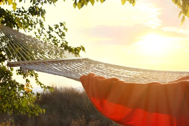 Photo of Hammock with blanket hanging outdoors. Time to relax