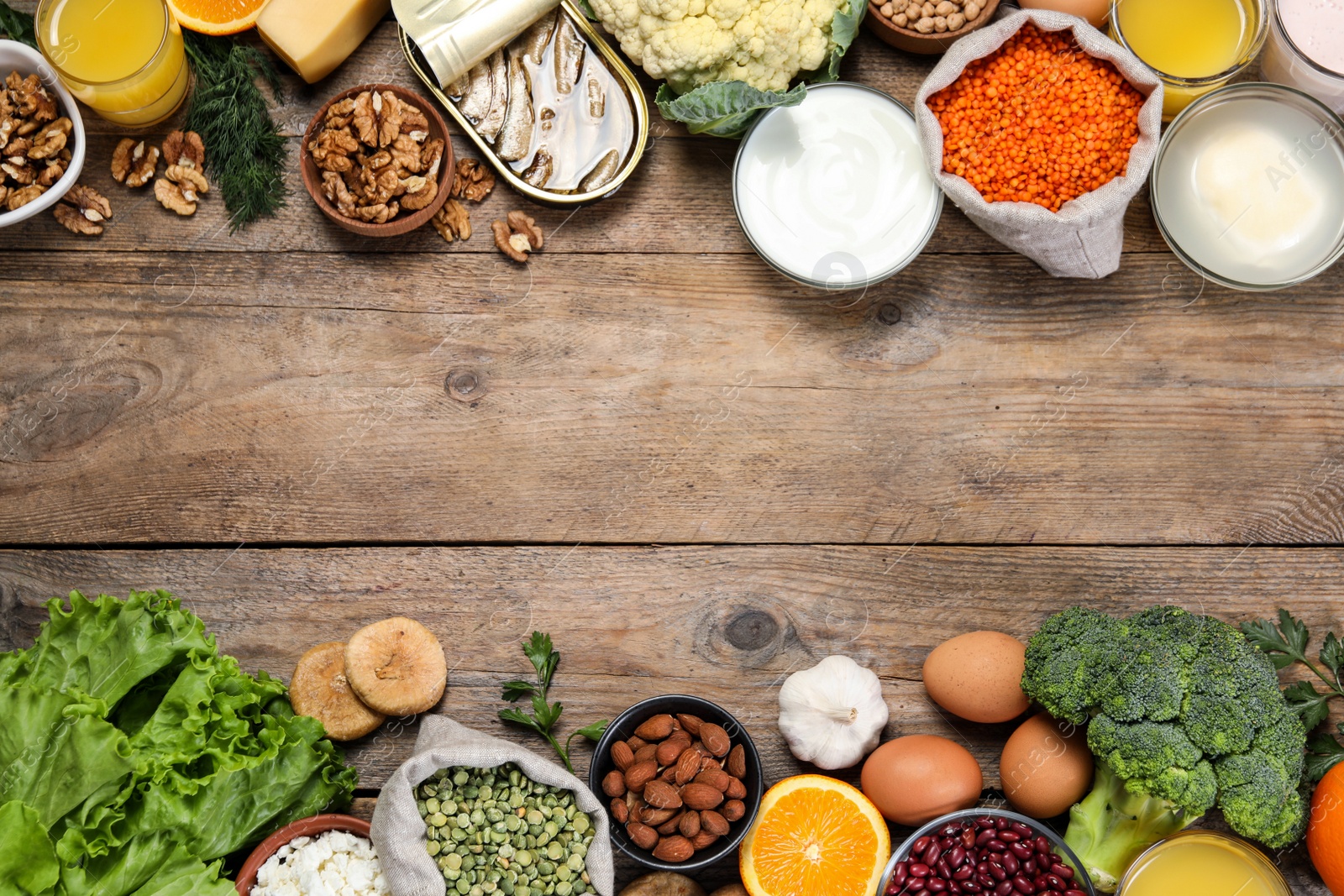 Photo of Set of natural food high in calcium on wooden table, flat lay. Space for text