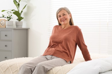 Photo of Beautiful senior woman relaxing on bed at home