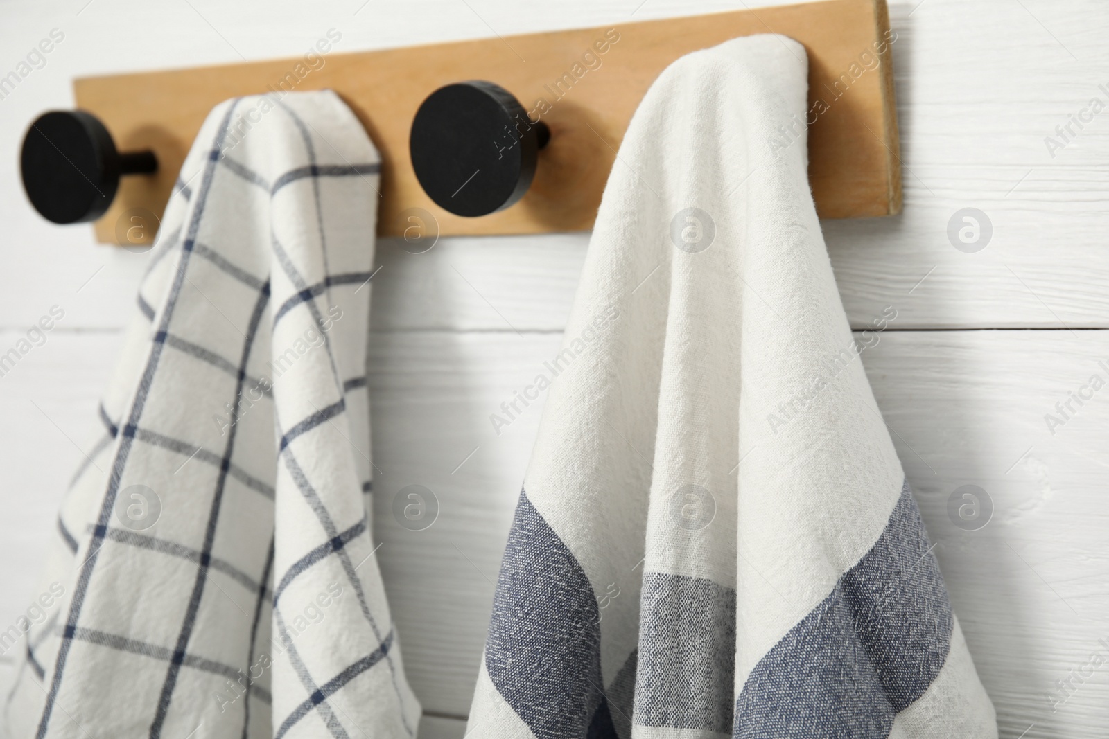 Photo of Clean kitchen towels hanging on rack, closeup