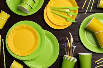 Photo of Flat lay composition with disposable tableware on wooden background
