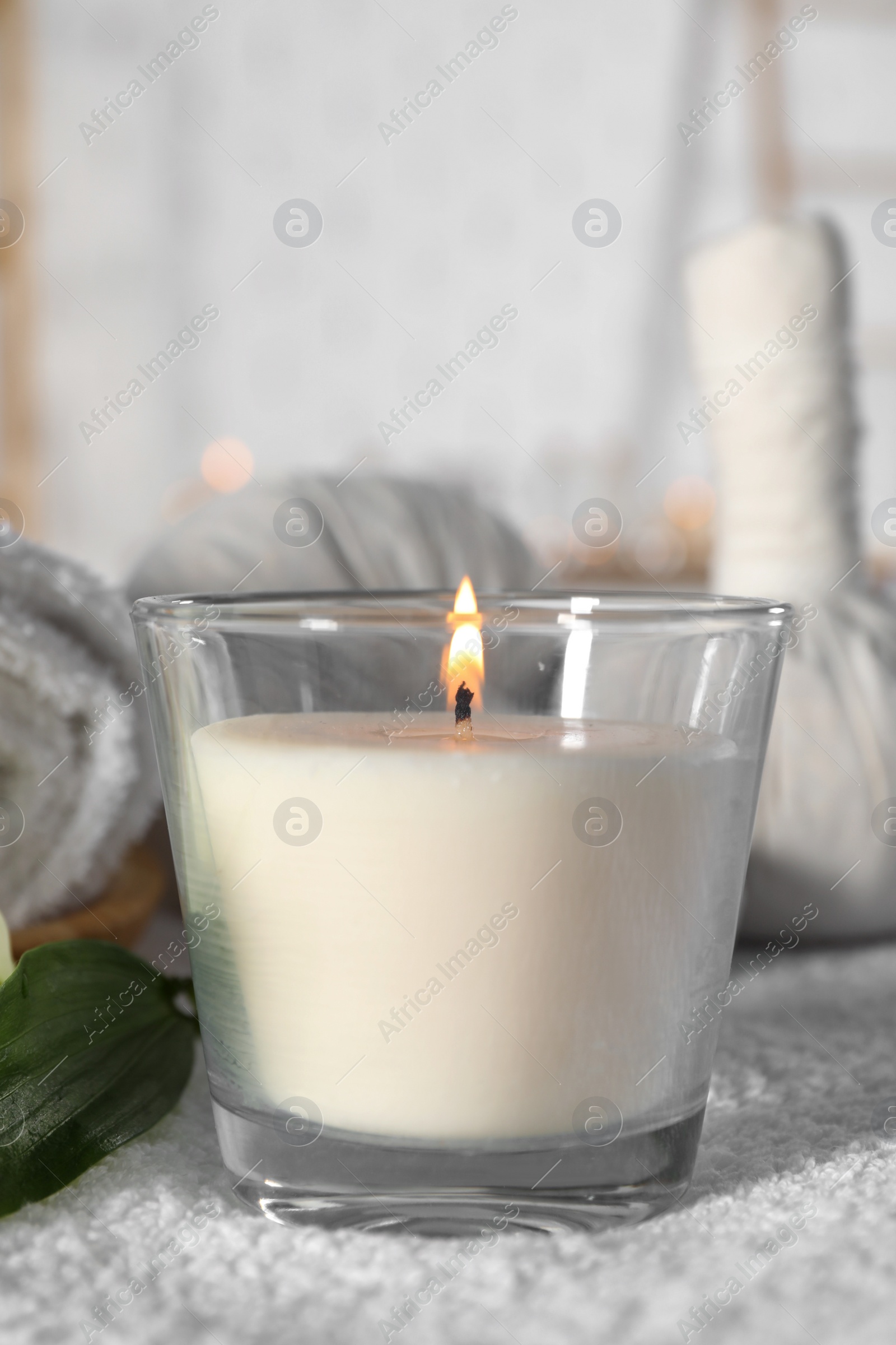 Photo of Spa composition with burning candle and herbal bags on massage table in wellness center