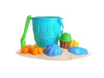 Set of plastic beach toys and pile of sand on white background