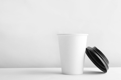 Photo of Takeaway paper coffee cup and lid on white background. Space for design