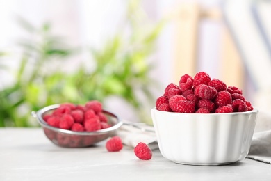 Photo of Bowl with ripe aromatic raspberries on table