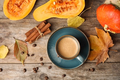 Photo of Flat lay composition with pumpkin spice latte in cup on wooden background