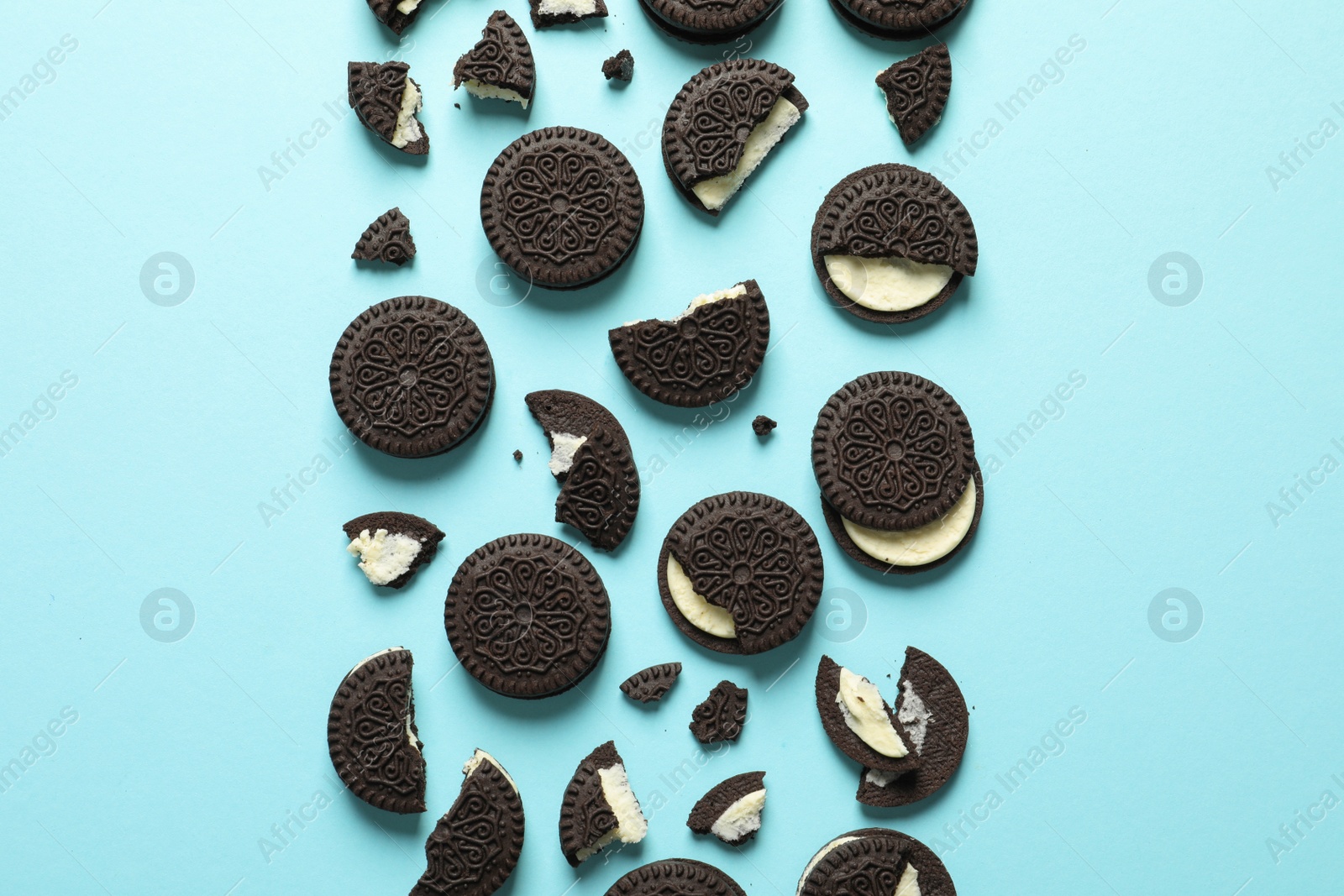 Photo of Tasty chocolate cookies with cream on color background, flat lay