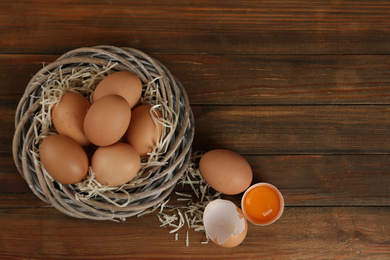 Raw chicken eggs on wooden table, flat lay