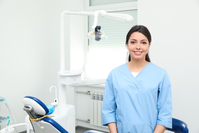 Photo of Portrait of professional female dentist in clinic. Space for text