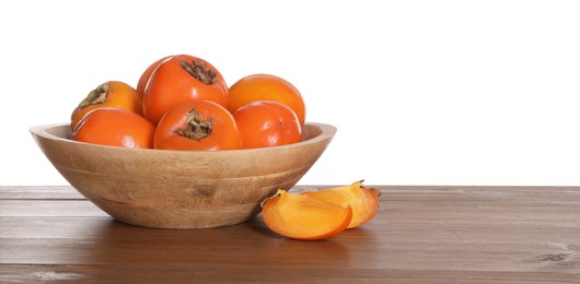 Photo of Delicious ripe juicy persimmons with bowl on wooden table against white background