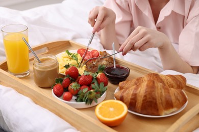 Photo of Woman having tasty breakfast on bed, closeup