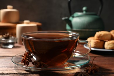 Aromatic tea with anise stars on wooden table, closeup