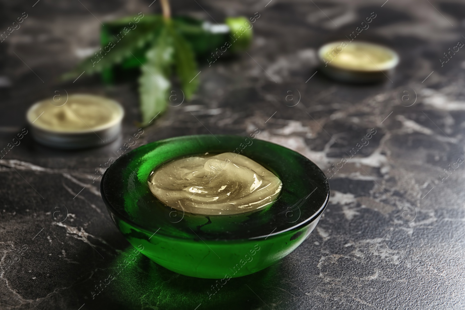 Photo of Bowl with hemp lotion on marble table