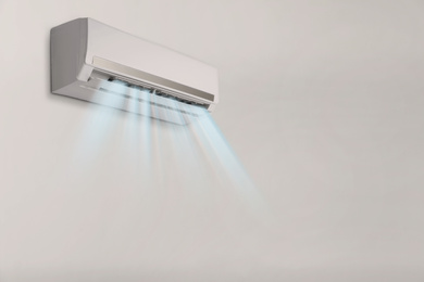 Image of Modern air conditioner on light wall indoors