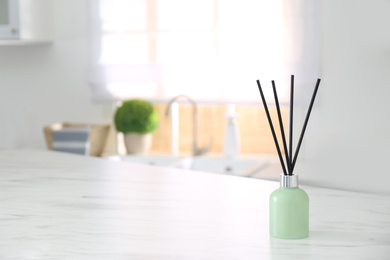 Photo of Aromatic reed air freshener on light table indoors. Space for text