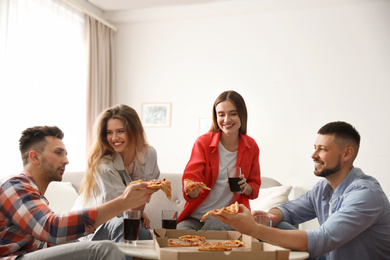 Group of friends eating tasty pizza at home