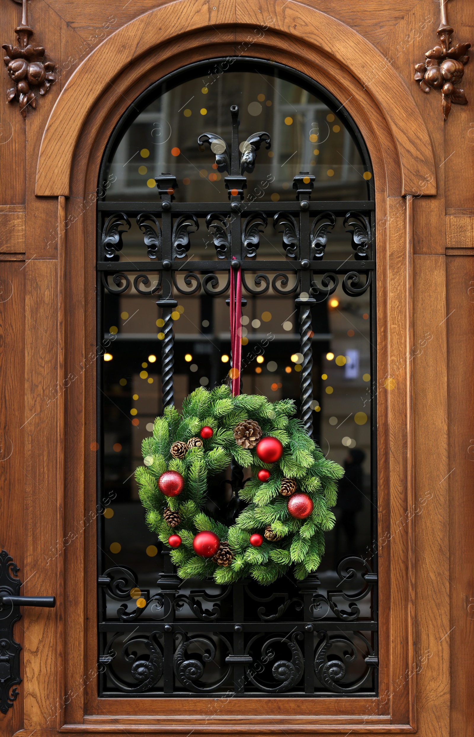 Photo of Beautiful Christmas wreath hanging on wooden door