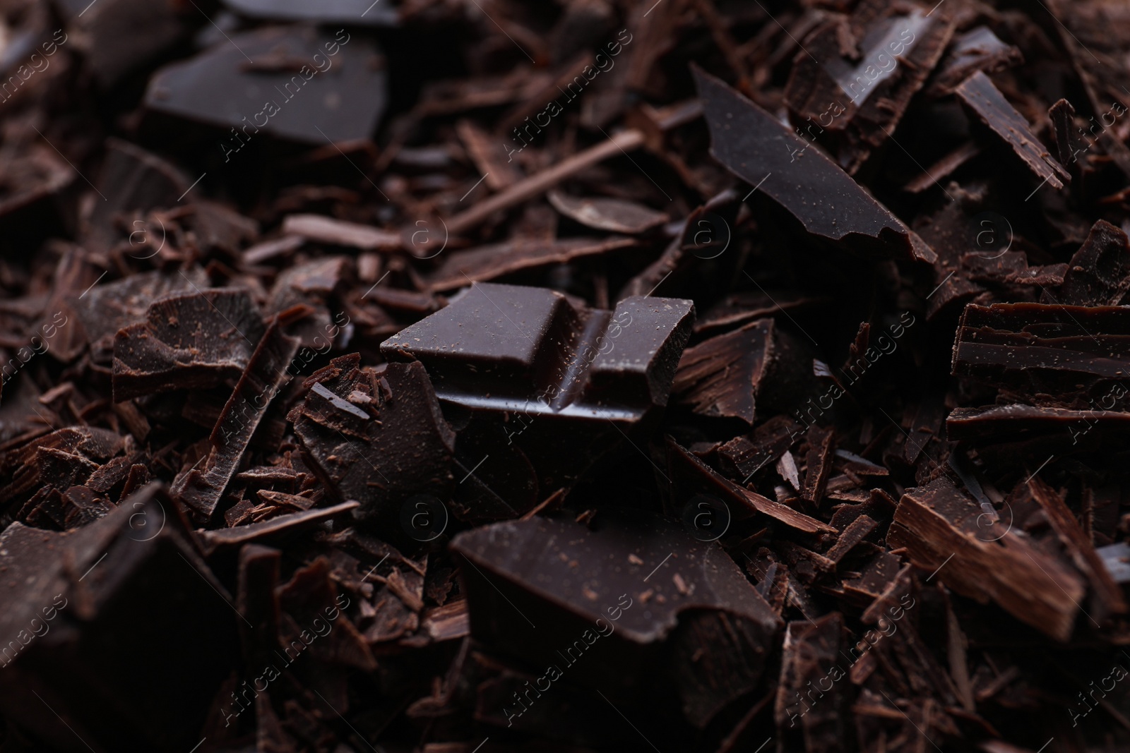 Photo of Tasty crushed dark chocolate as background, closeup