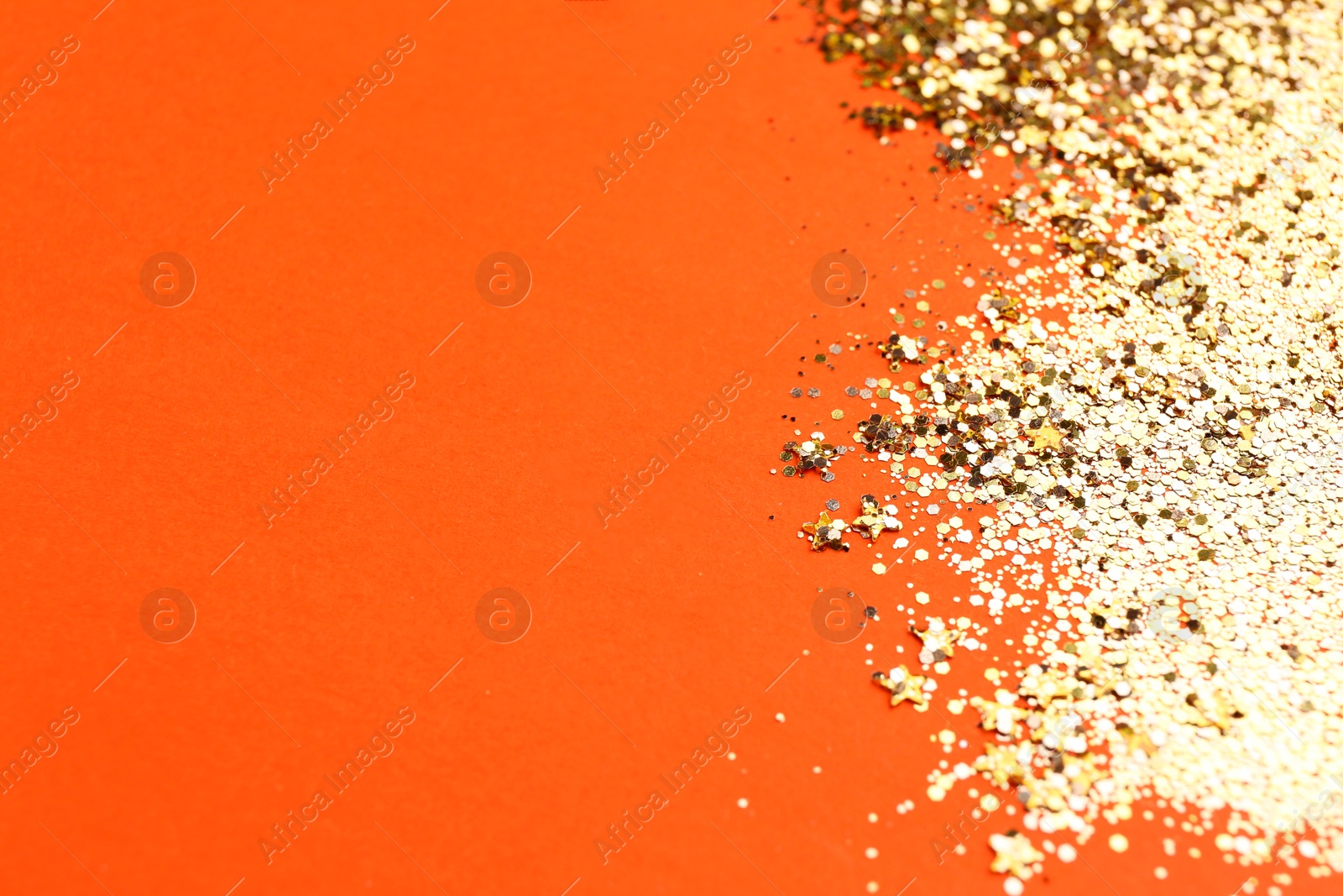 Photo of Shiny bright golden glitter on pale coral background. Space for text