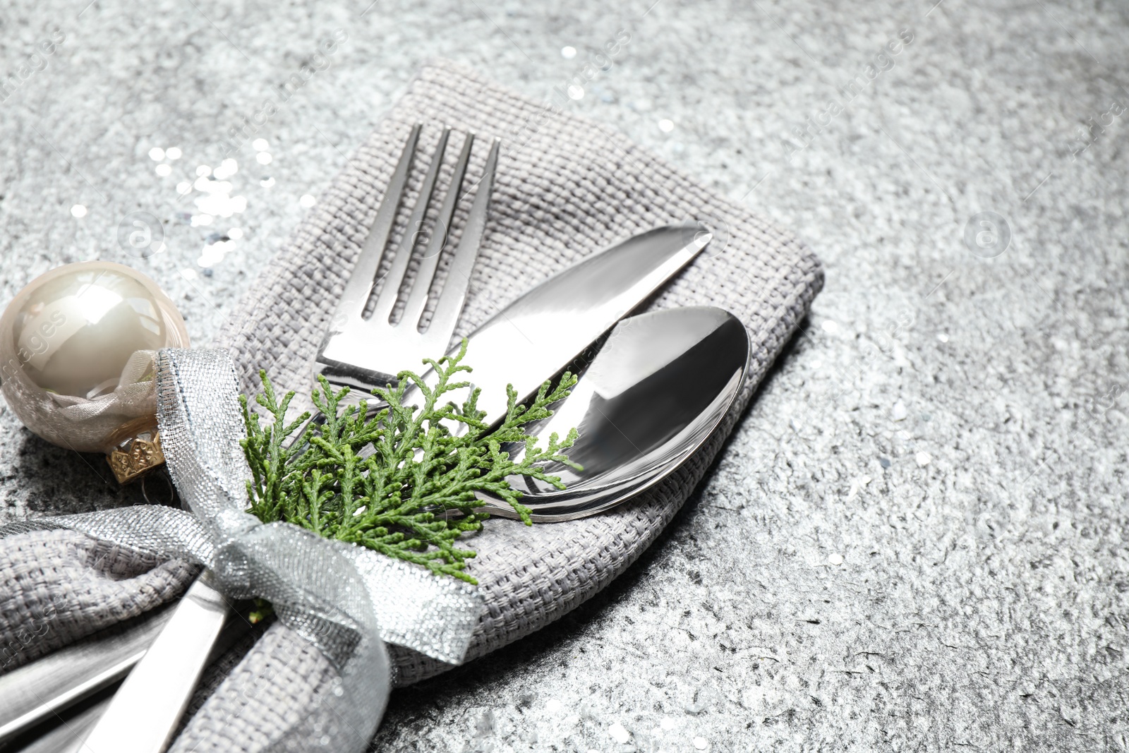 Photo of Cutlery set on grey textured table, closeup. Christmas celebration