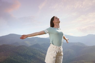 Photo of Beautiful young woman in peaceful mountains on sunny day. Feeling freedom