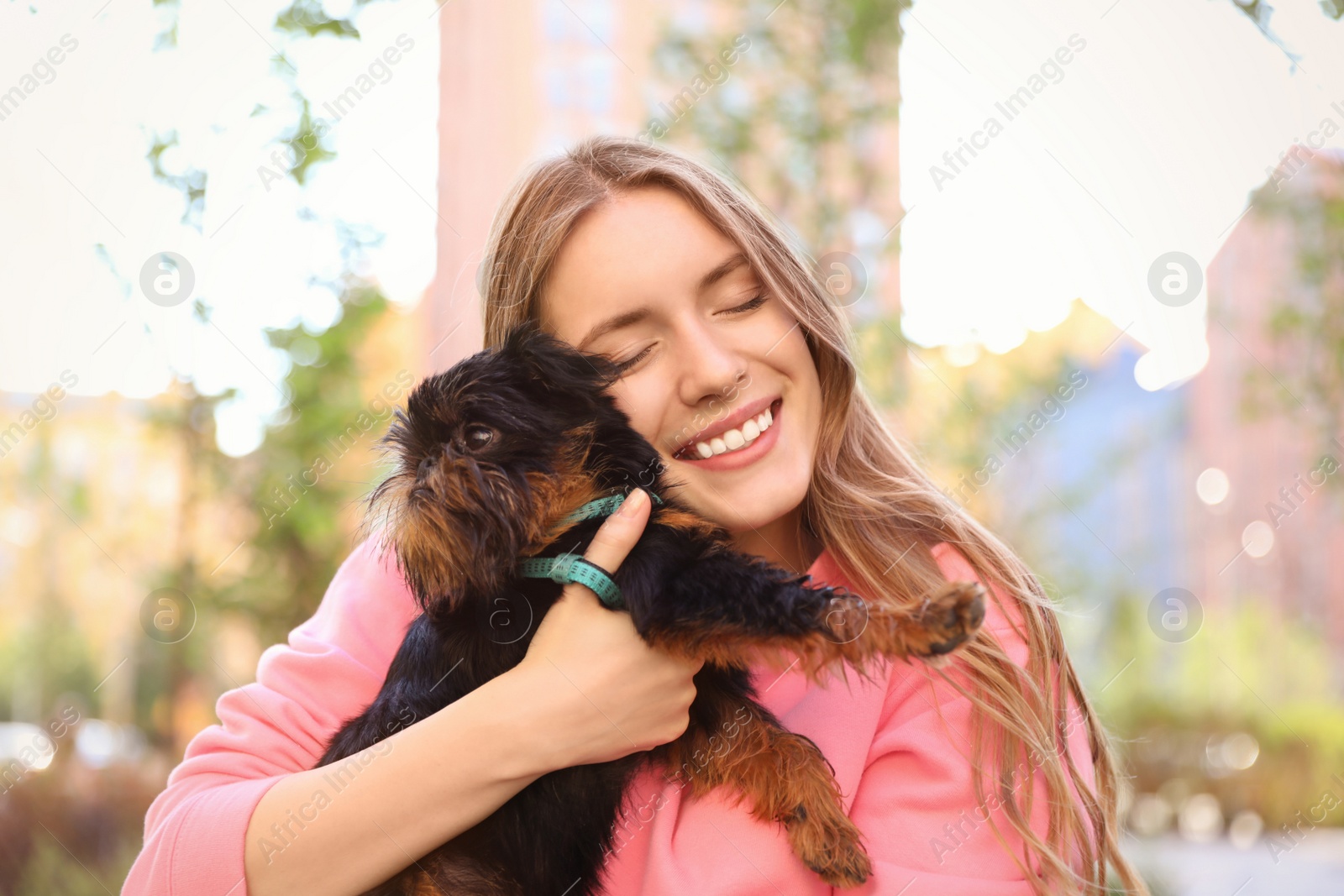 Photo of Young woman with adorable Brussels Griffon dog outdoors