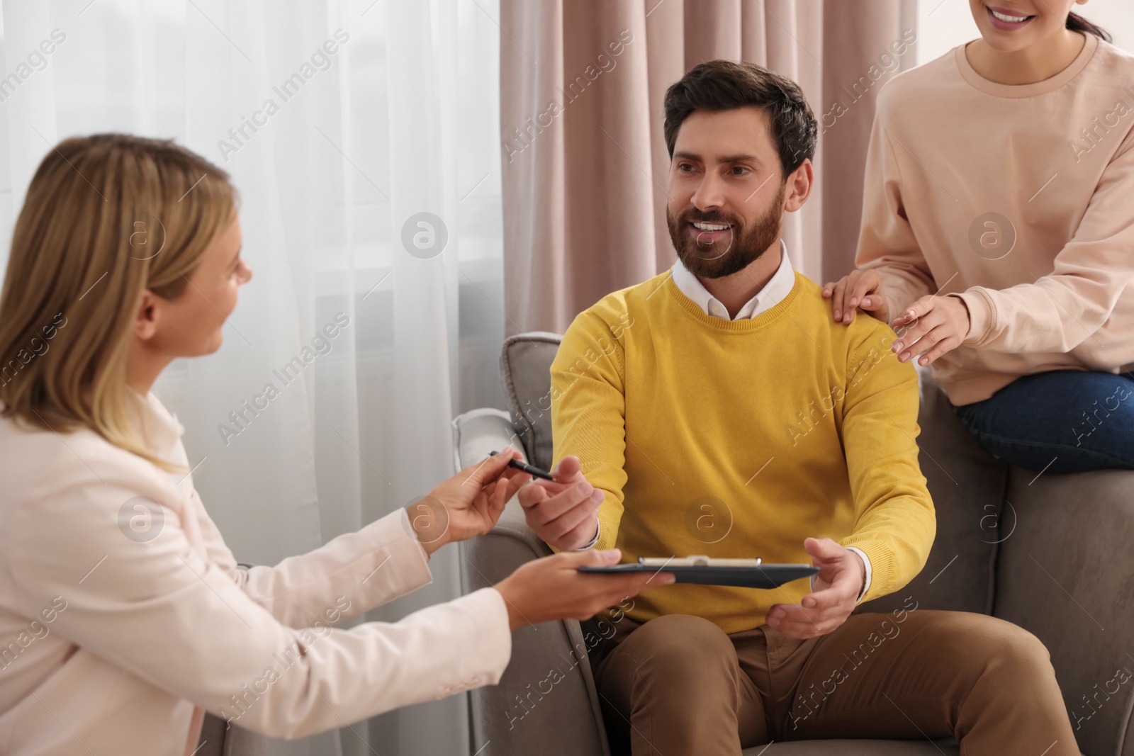 Photo of Real estate agent and couple signing contract in new apartment