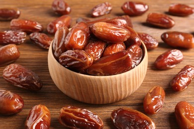 Photo of Many sweet dried dates on wooden table