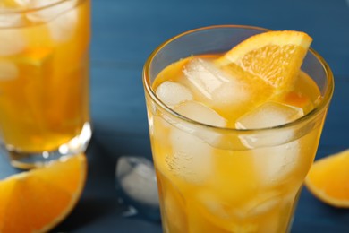Photo of Delicious orange soda water on blue background, closeup
