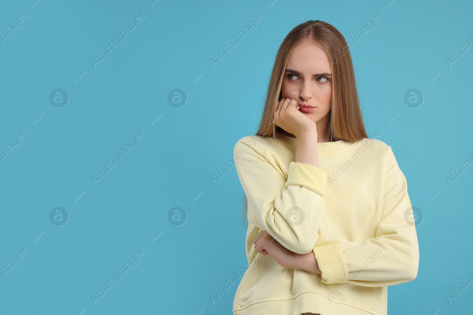 Photo of Resentful woman on light blue background, space for text