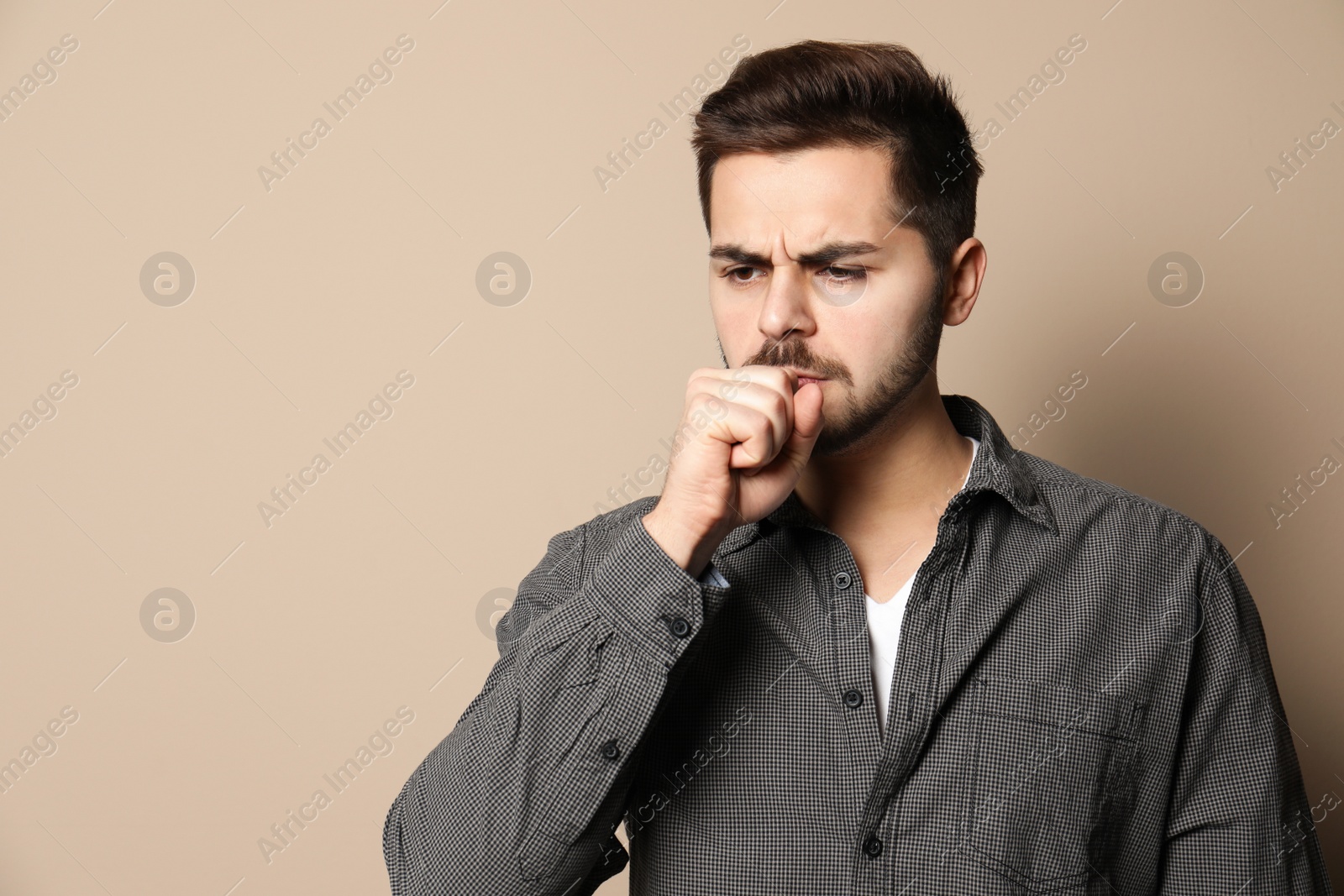 Photo of Handsome young man coughing against color background. Space for text