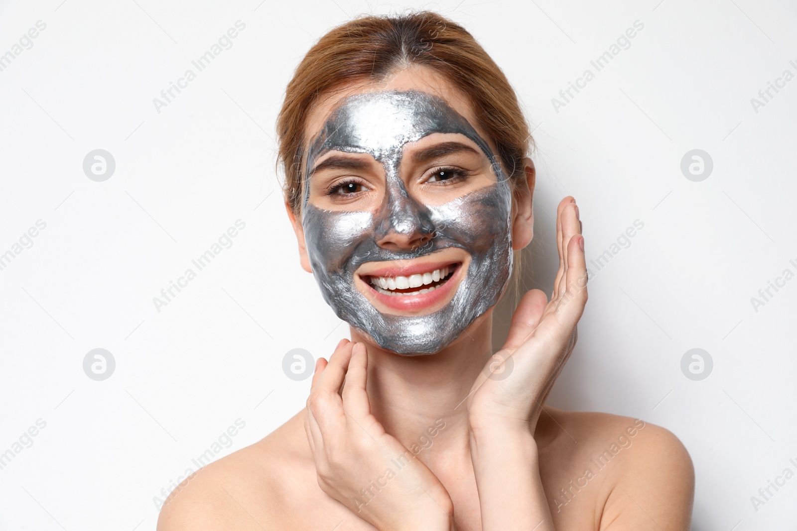 Photo of Beautiful woman with mask on face against light background