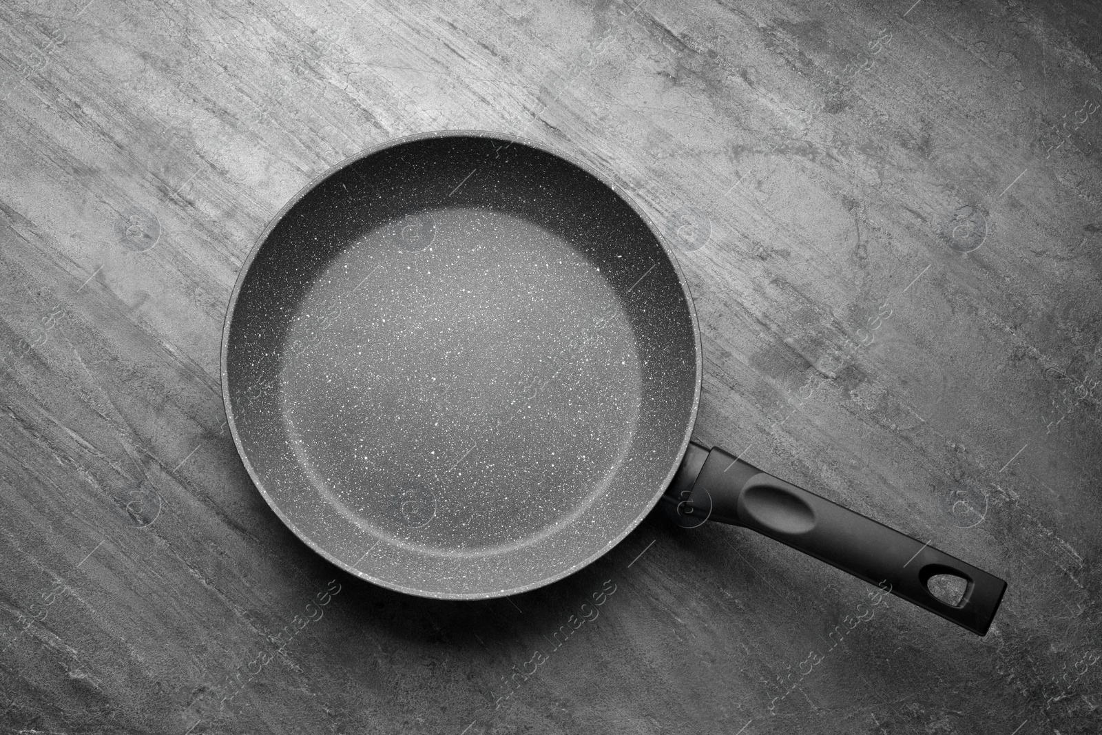 Photo of New non-stick frying pan on grey table, top view