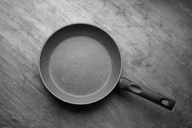New non-stick frying pan on grey table, top view