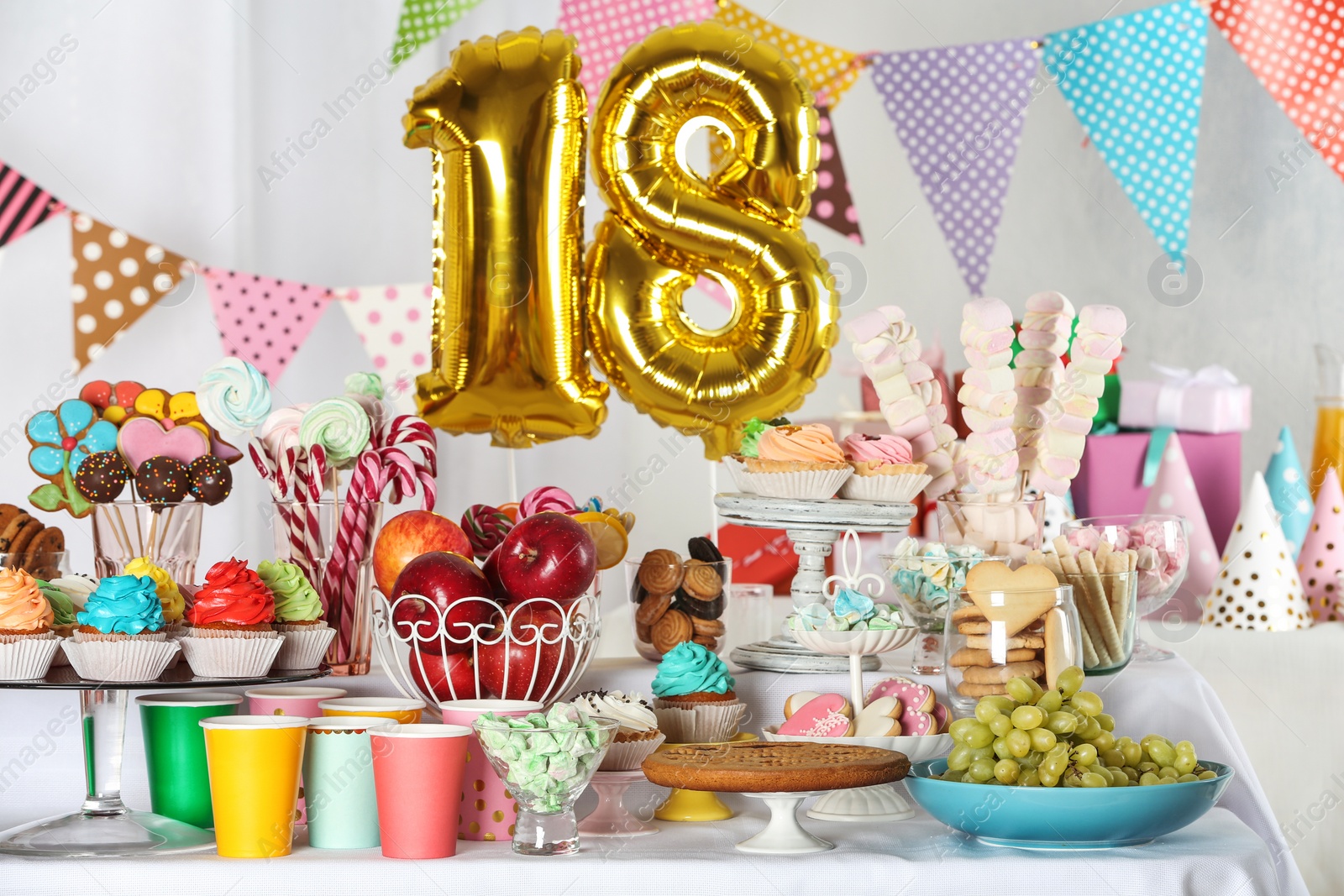 Photo of Dessert table in room decorated with golden balloons for 18 year birthday party