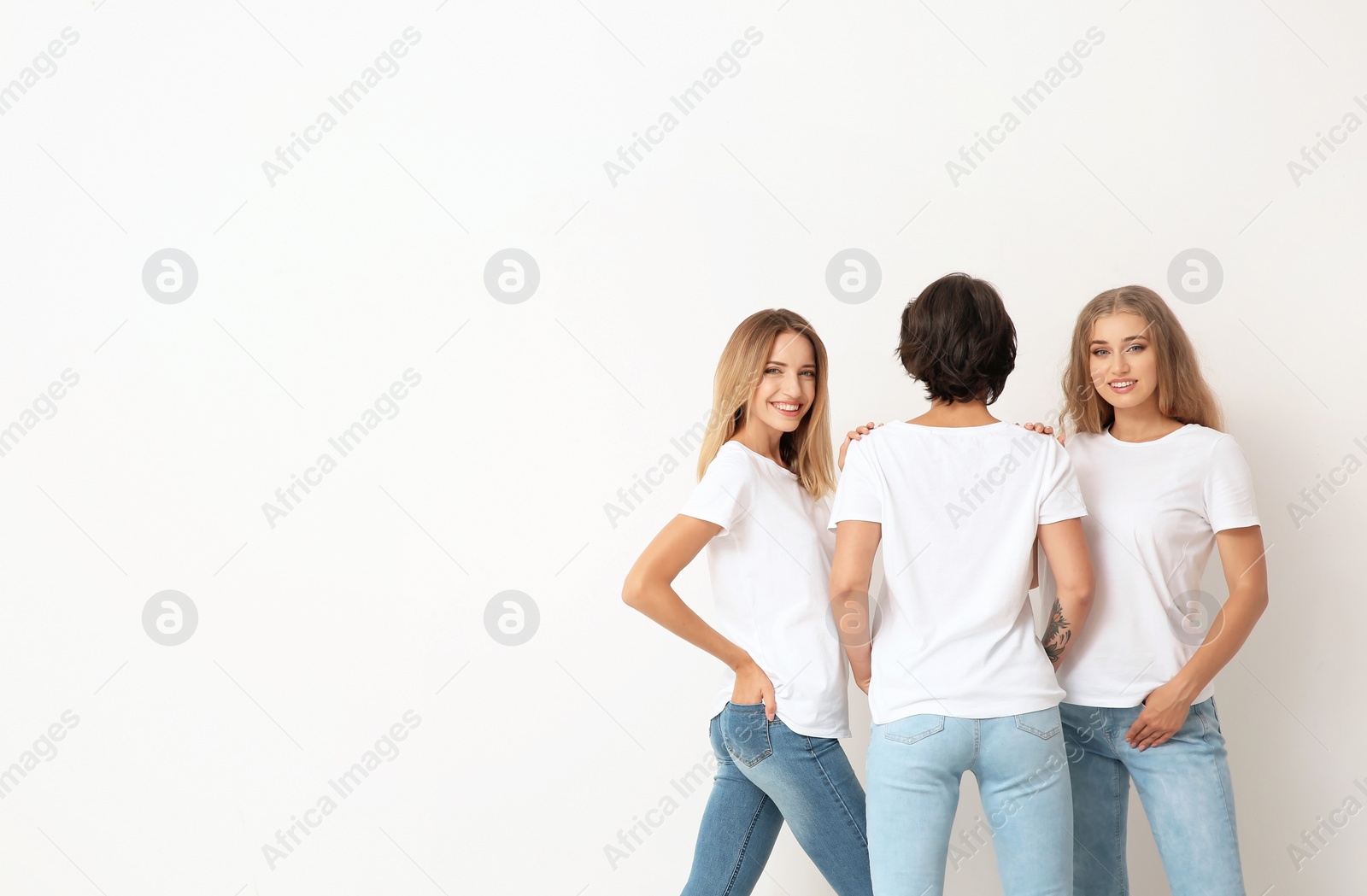 Photo of Group of young women in jeans on light background