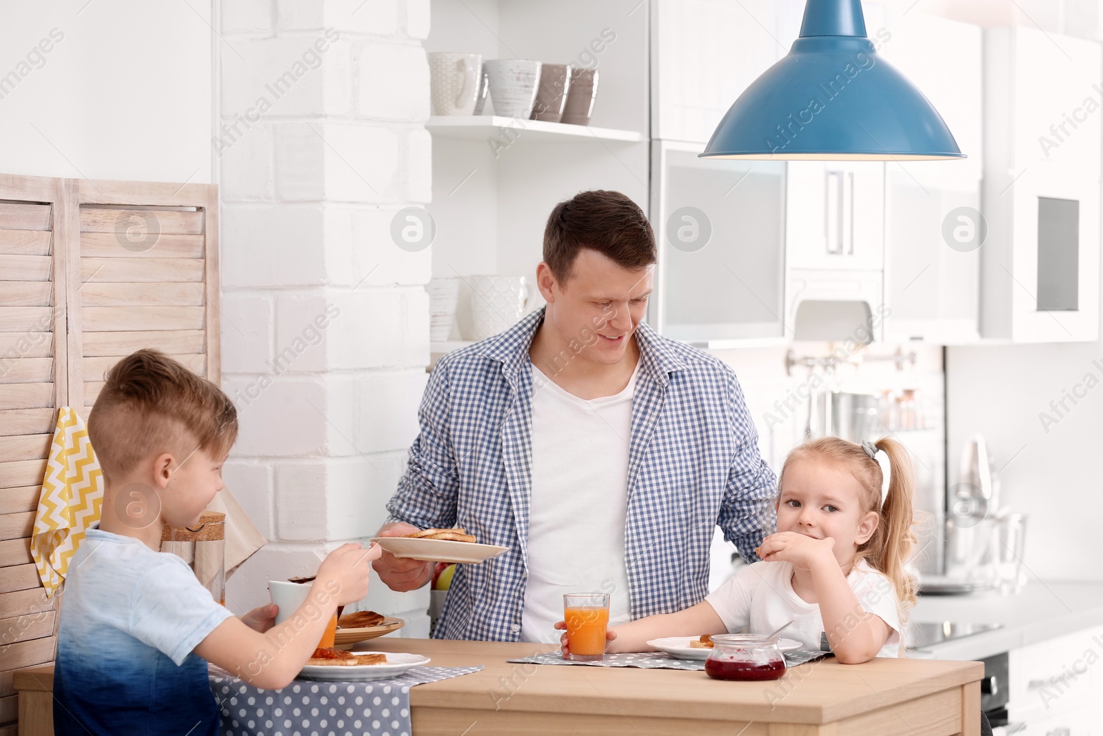 Photo of Father and cute little children having breakfast with tasty toasted bread at table