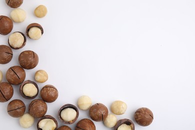 Photo of Tasty Macadamia nuts on white background, flat lay. Space for text