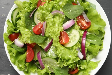 Photo of Delicious salad in bowl on grey table, top view