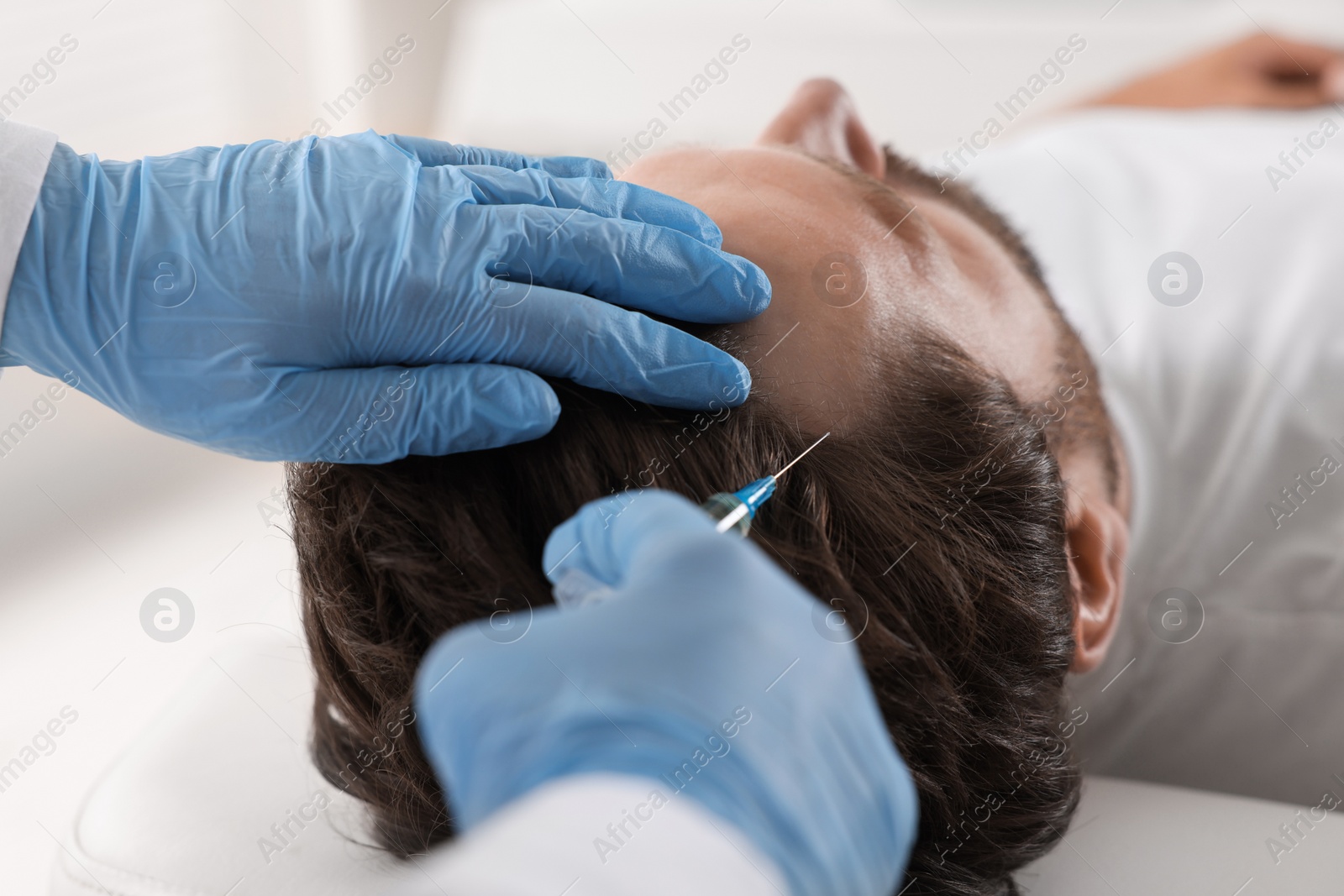 Photo of Trichologist giving injection to patient in clinic, closeup