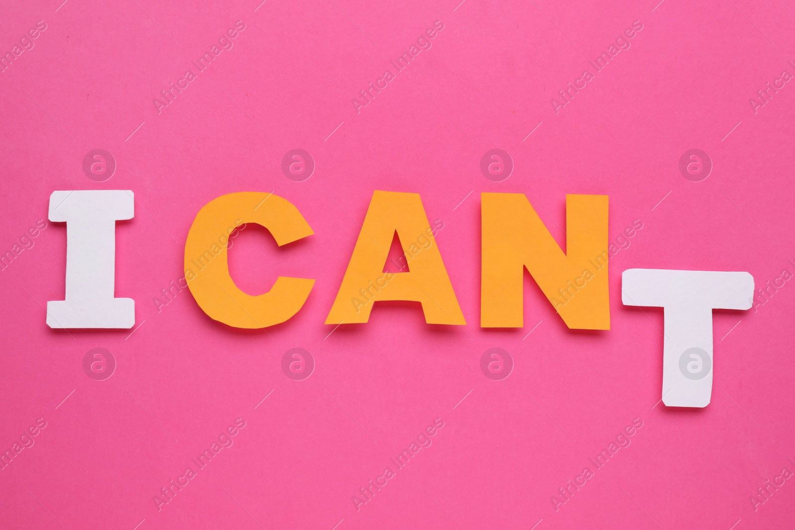 Photo of Motivation concept. Changing phrase from I Can't into I Can by removing paper letter T on pink background, top view