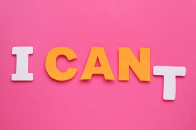 Photo of Motivation concept. Changing phrase from I Can't into I Can by removing paper letter T on pink background, top view