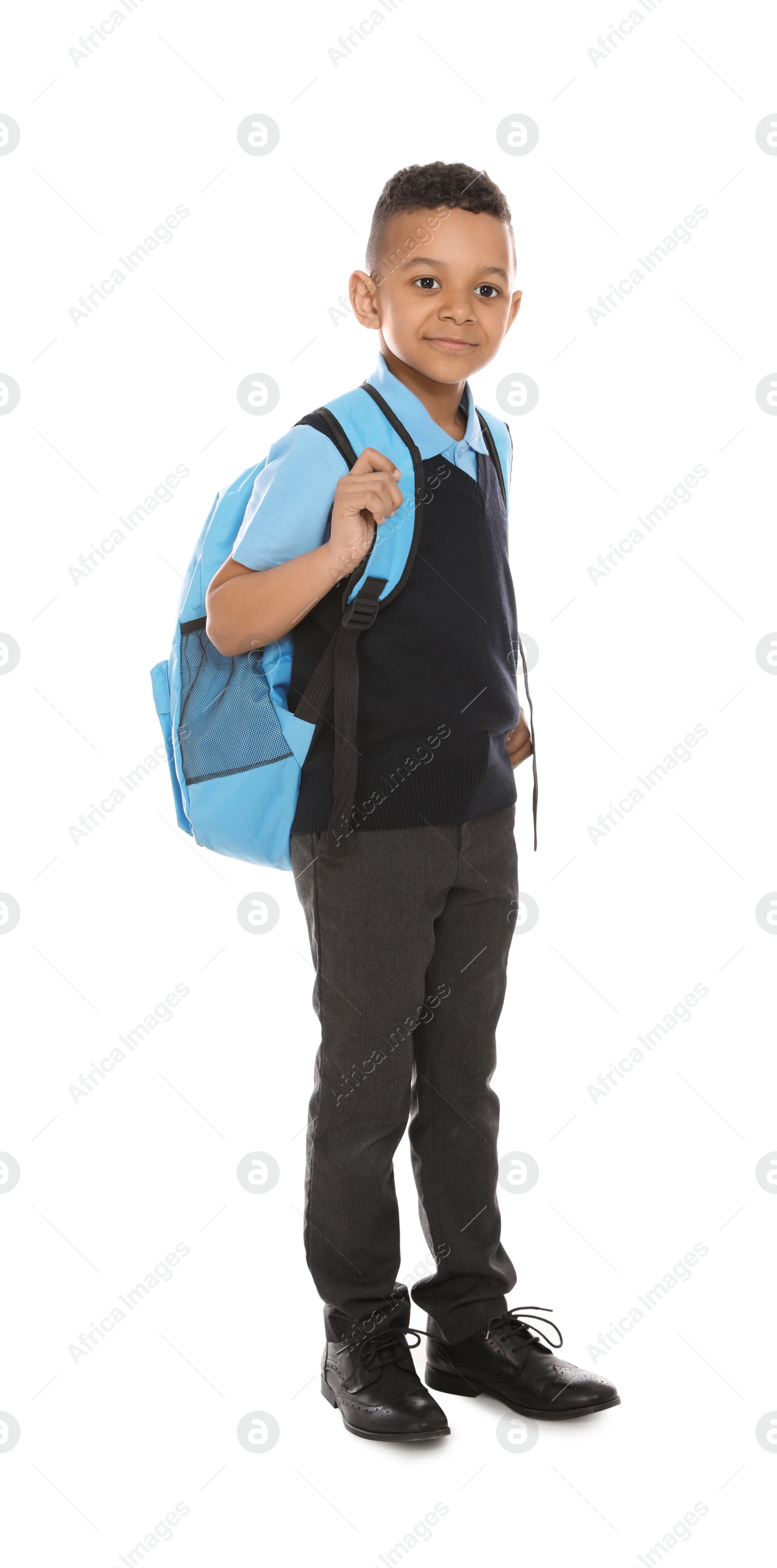 Photo of Full length portrait of cute African-American boy in school uniform with backpack on white background
